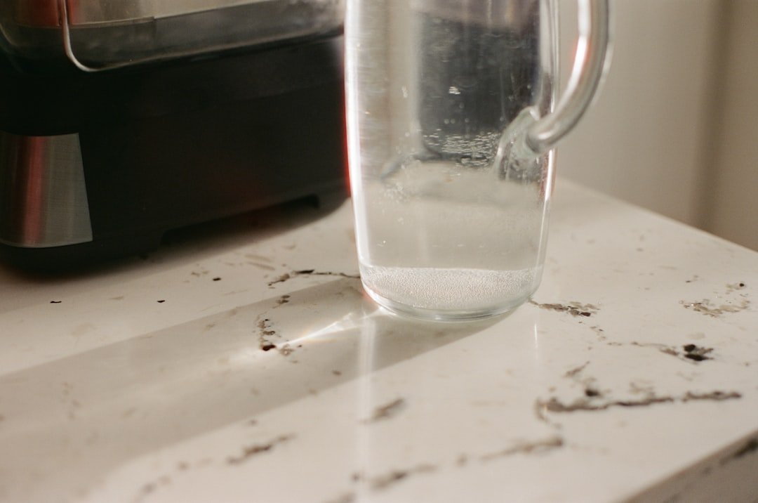 Clear glass pitcher with water on a countertop.